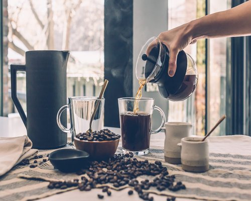 Person pouring water into a glass in a quiet morning kitchen