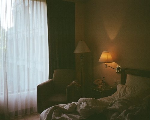 A comfortable bedroom with dim, relaxing evening lighting